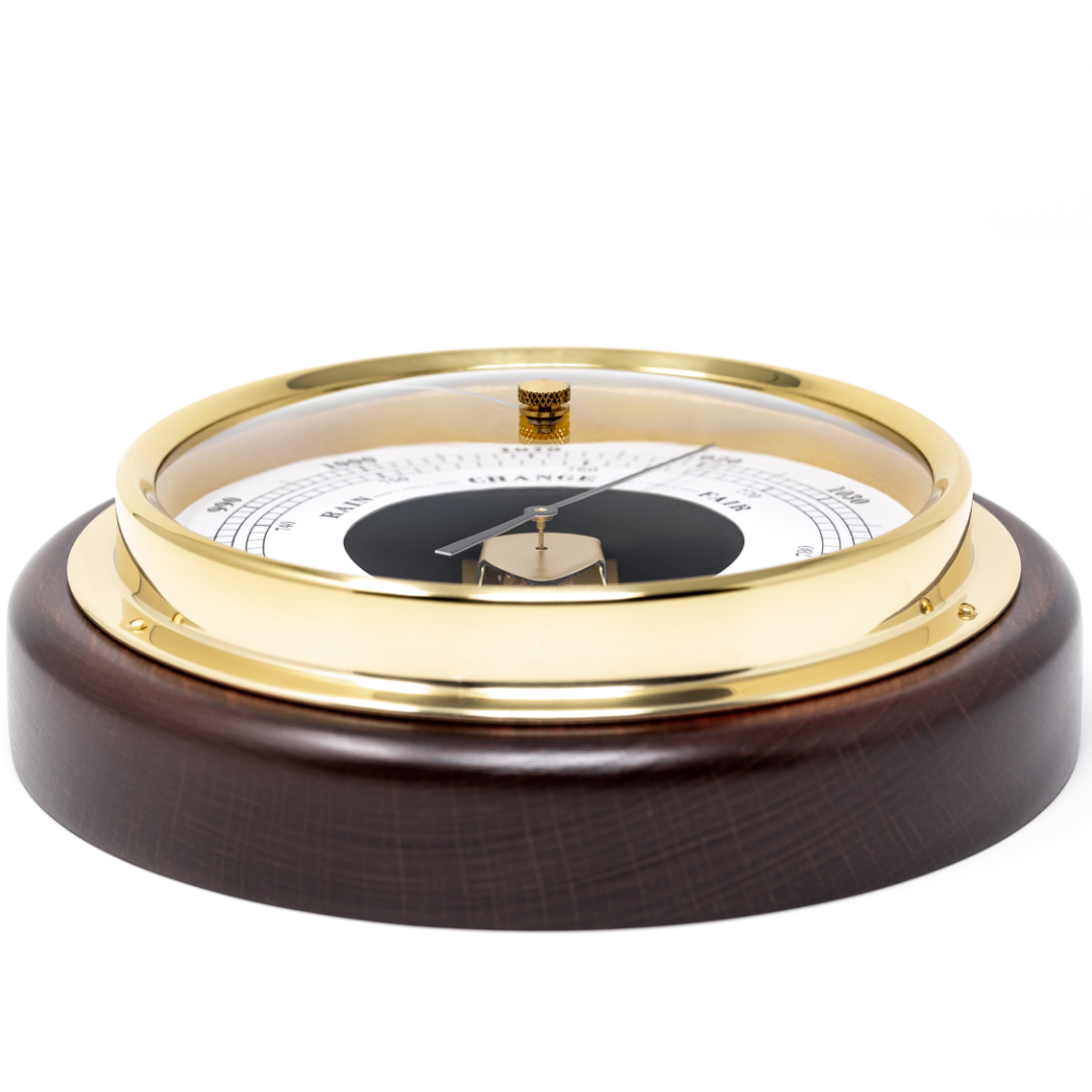 Gold and wood analog barometer with white dial for measuring air pressure