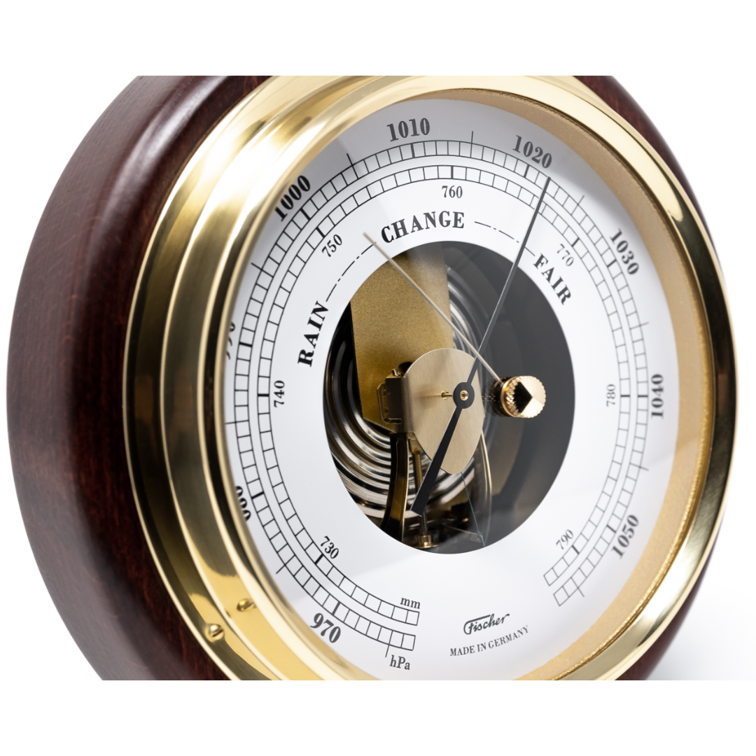 Close-up of a German barometer with brass trim, wood housing, and clear weather dial.