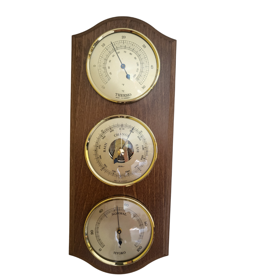Wall-mounted oak weather station with brass barometer, thermometer, and hygrometer dials