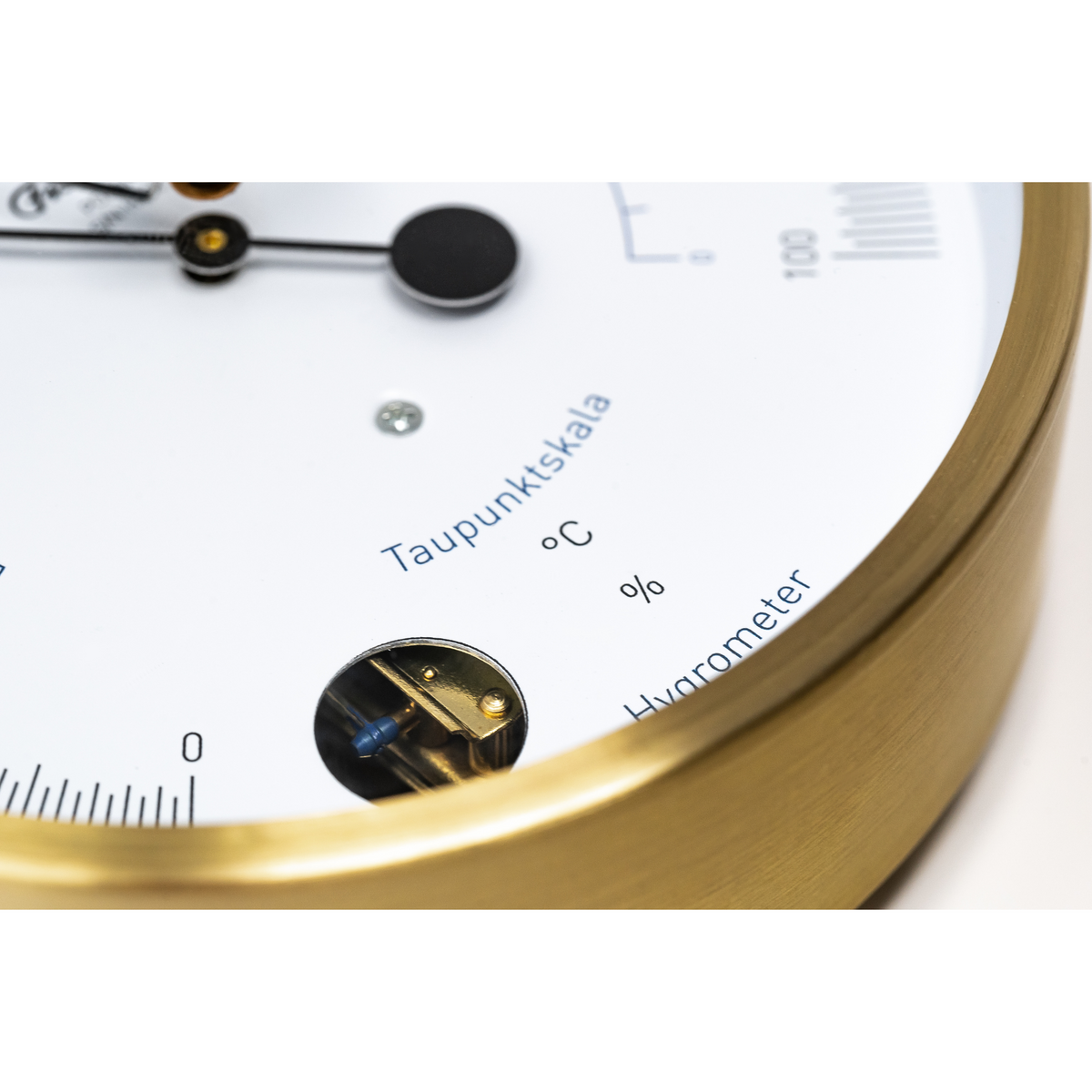 Close-up of a brass analog hygrometer and dew point scale, precision weather instrument
