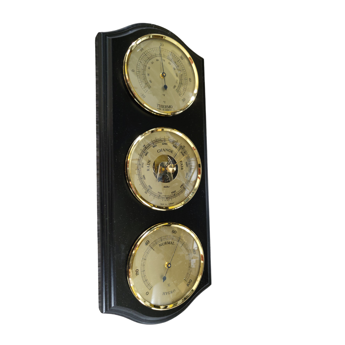 Gold-trimmed barometer, hygrometer, and thermometer weather station on wall indoors