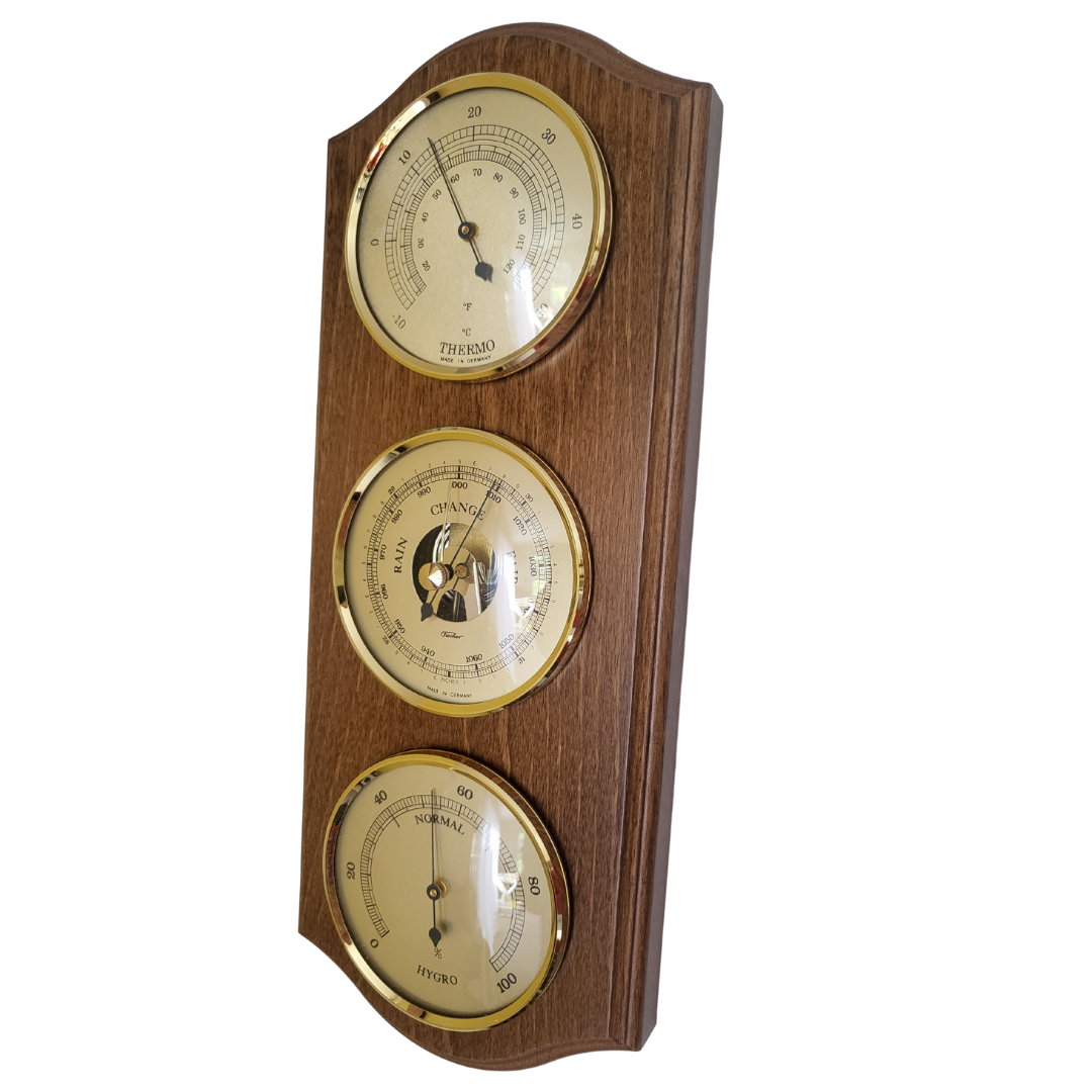 Rustic oak weather station with brass barometer, hygrometer, and thermometer dials.
